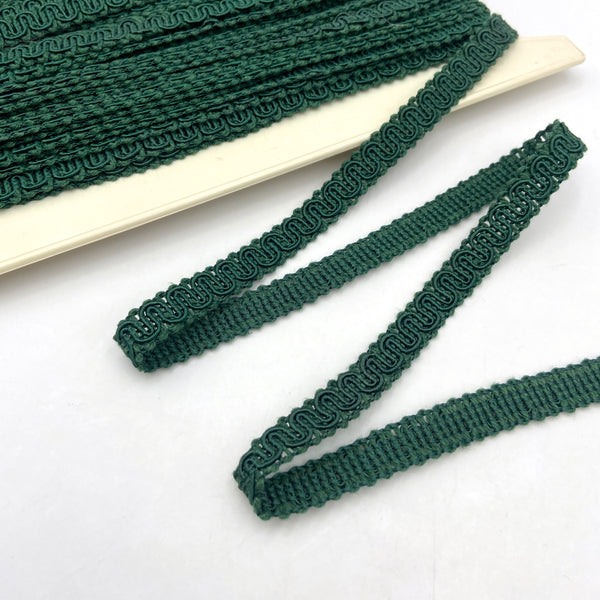Green trim made from braided and twisted cords that form a snaking design.