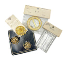 Collection of gold and silver buckles on display cards against a light gray background