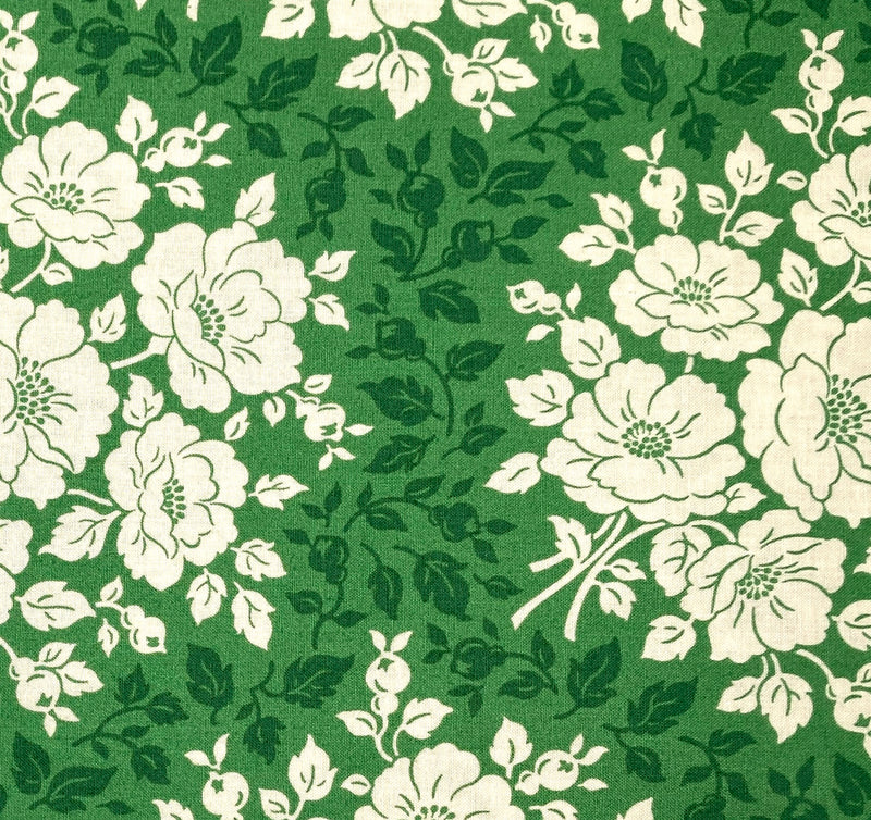 Deep green and ivory floral designs with a lighter green background printed on a 100% cotton fabric.
