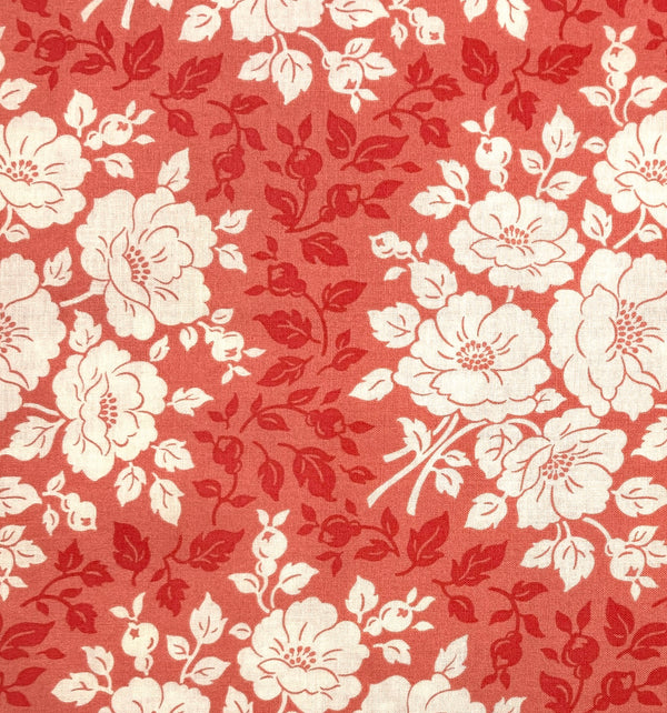 A 100% quilting cotton with vine and floral motifs printed in ivory and shades of coral pink.