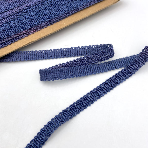 Blue trim made from braided and twisted cords that form a snaking design.