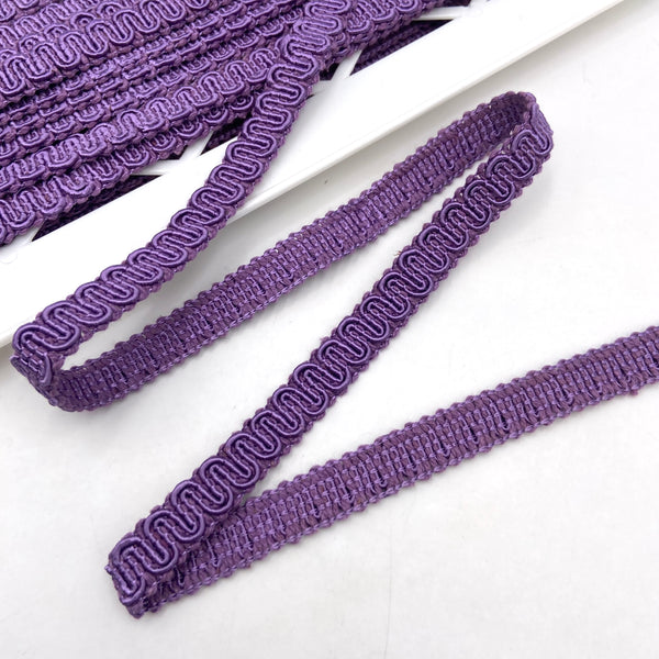 Purple trim made from braided and twisted cords that form a snaking design.
