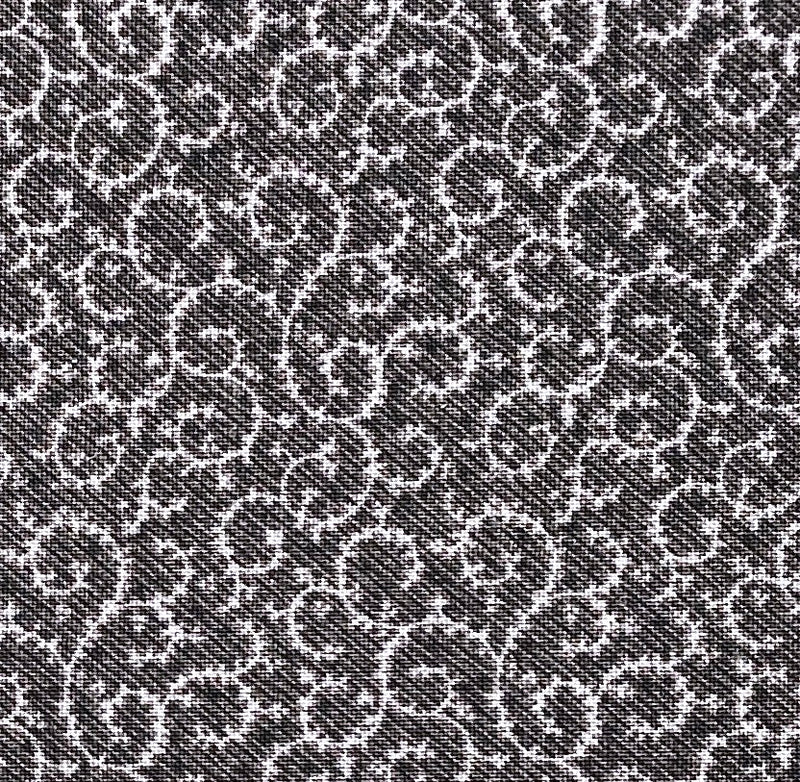 A quilting fabric with light grey swirl designs on a mottled black background.