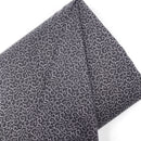 A bolt of quilting cotton in grey and black with vining swirl designs. 