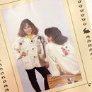 Two girls wearing similar jackets with different applique patterns, posing for a photo.