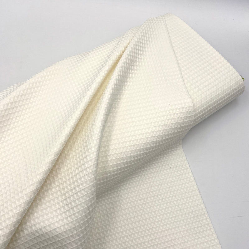 A bolt of 100% cotton waffle weave fabric in white. 