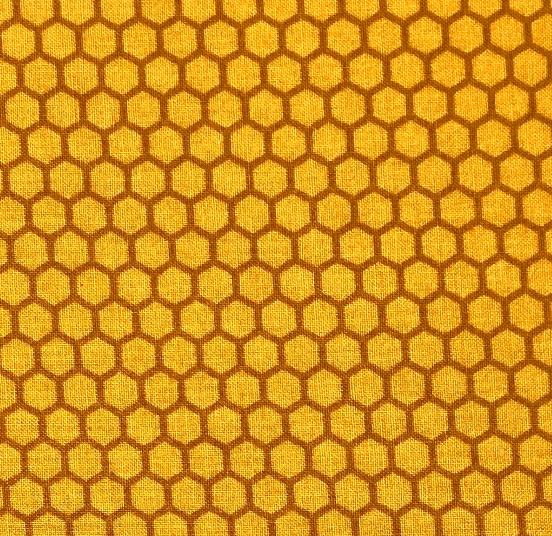 A 100% cotton quilting fabric with a honeycomb design in shades of golden yellow.