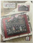 Hands on Design cross-stitch kit packaging with 'Winter Wonderland Farm' design on a wooden surface.