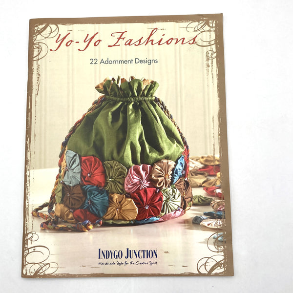 Front cover of book featuring a silk drawstring purse adorned with multi-colored silk yo-yos.