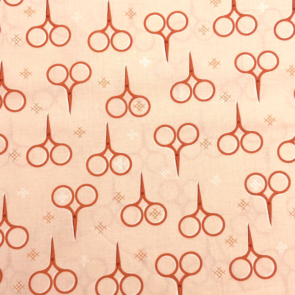 peach quilting fabric with a little scissors print