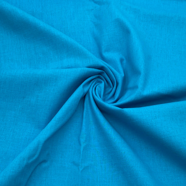 A slightly slubby blue fabric scrunched into a swirl in the middle. 
