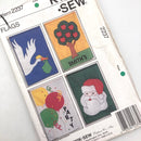 Kwik Sew 2237 pattern cover for flags, featuring various designs including a white dove, a red apple tree, Santa's outfit, and a reindeer. The cover is old with visible signs of wear.