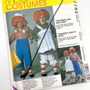 A photo of the cover of a McCall's costume pattern book, featuring images of children and adults modeling Raggedy Ann and Andy costumes.