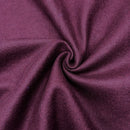 Close-up of red purple fabric scrunched in a swirl to show the texture of the fabric