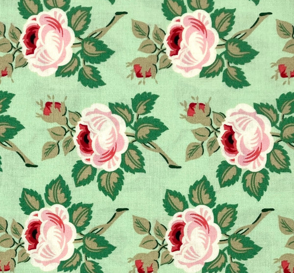 A 100% cotton quilting fabric featuring a sweet pink and red floral on a soft mint green background. 