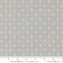 Fabric pattern with small floral designs on a gray background, featuring a ruler for scale.