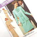 A photo of the cover of a Simplicity fashion pattern book, featuring a picture of a woman in a green dress with a necktie and a man in a suit, along with illustrations of the dress and cardigan patterns.