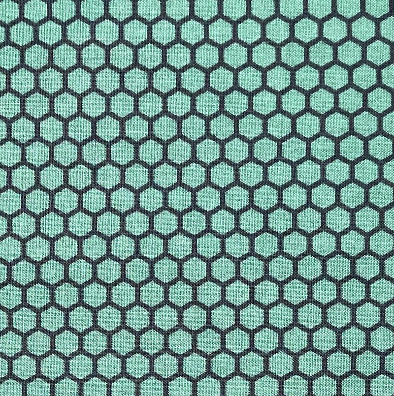A 100% cotton quilting fabric with a honeycomb design in a light calming green and black.
