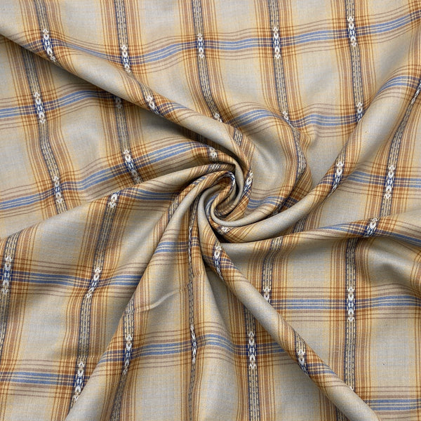 A close-up shot of cotton shirting fabric with a taupe and warm brown plaid design. The fabric is scrunched into a swirl in the middle to show the way it folds and moves. 