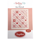 A quilt pattern cover for 'A Quilting Life' by Sherri McNaught, featuring a grid of heart-shaped blocks in various shades of red, white, and gray, with a pink background and the title text displayed prominently.