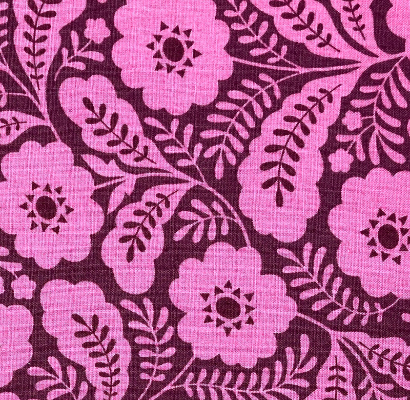 A close-up of a orchid-colored geometric floral quilting cotton fabric. 