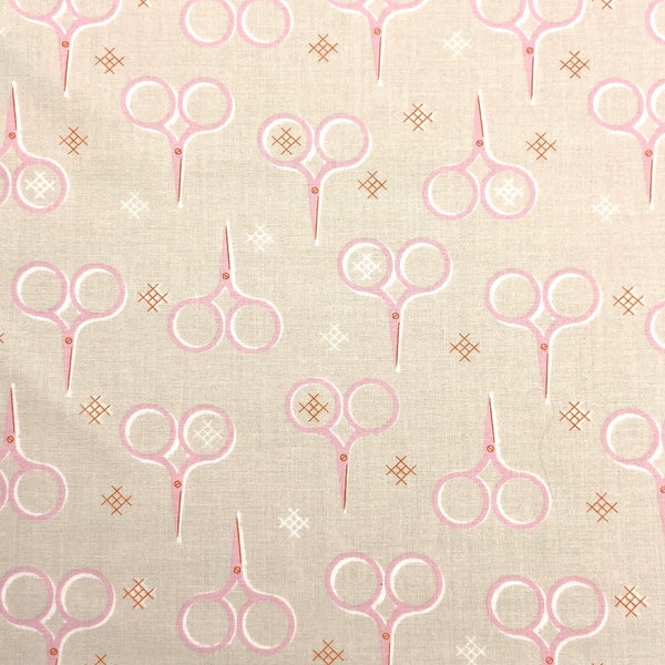 pink scissors printed on beige quilting fabric