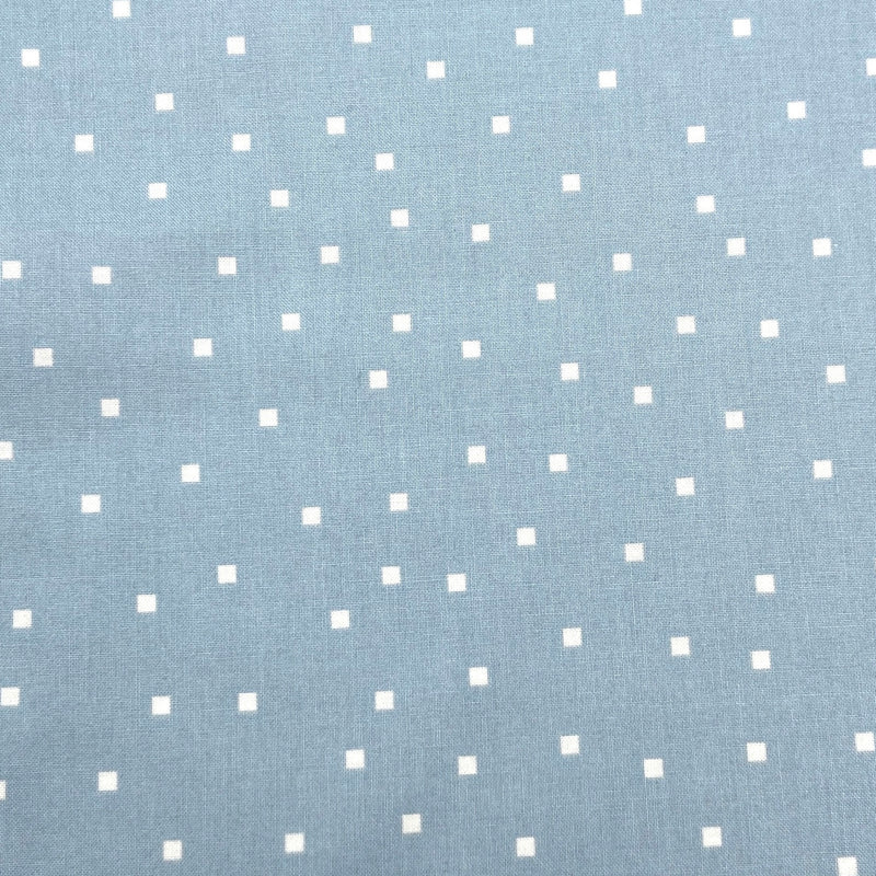 small white squares on a light blue background of quilting fabric