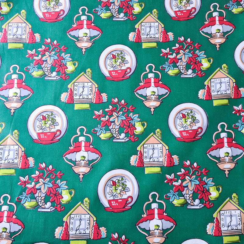 A close-up of green fabric with cottage-y motifs on it.