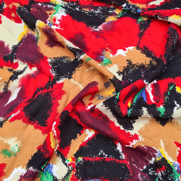 A rayon fabric with red, black, tan, and other multi-colored splotches throughout.
