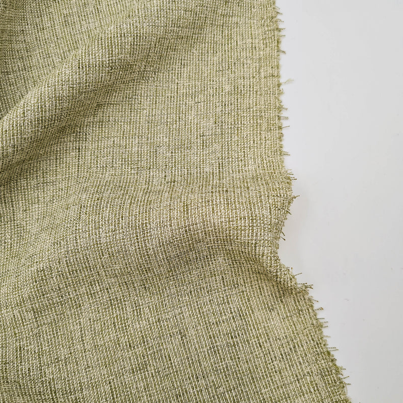 A close-up of a subtle green home decor fabric that has color variations throughout and a soft textured appearance