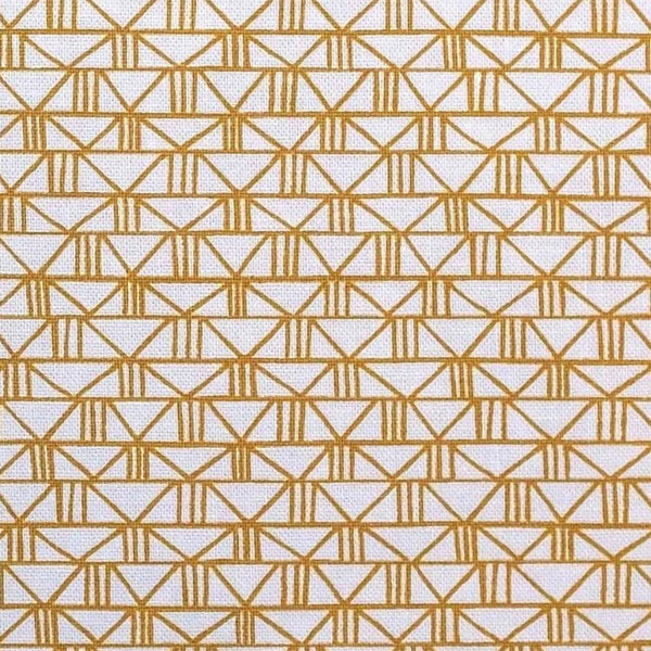 A very light pink fabric with a gold geometric print.