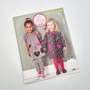 A cover image of a toddler's dress and leggings pattern set by Ellie Mae Designs, featuring two girls wearing the designed outfits.