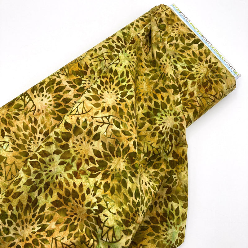 A bolt of green and yellow floral fabric with a batik style print.