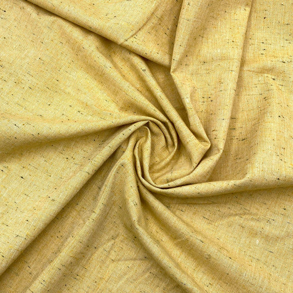 A yellow speckled chambray fabric scrunched in a swirl pattern to better show the texture and thickness of the fabric.