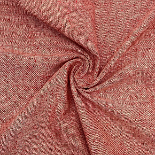 A red speckled chambray fabric is scrunched up in a swirl pattern to better show the fabric's texture