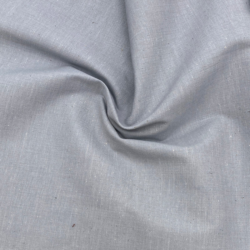 subtle blue-gray denim fabric scrunched in a swirl design to show the fabric's texture.