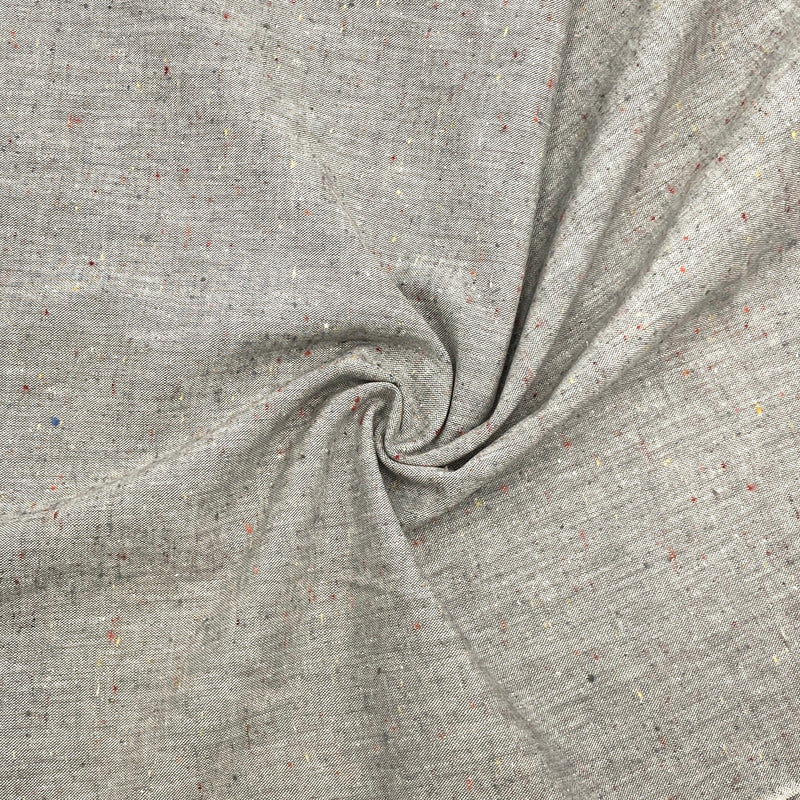 A light grey speckled chambray fabric is scrunched in a swirl pattern to show its texture and thickness