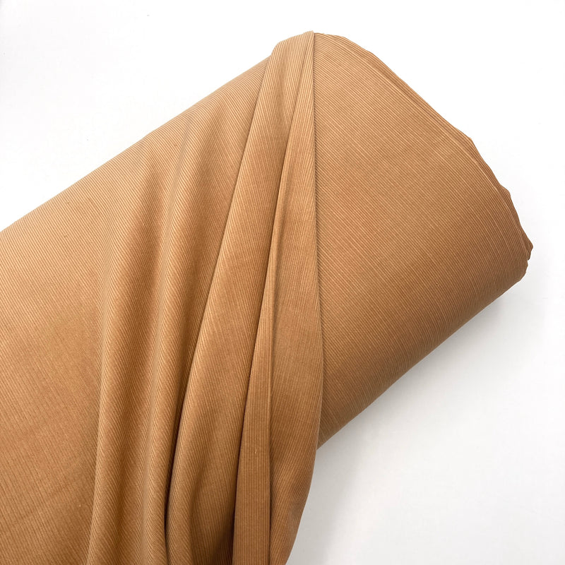 a bolt of camel brown corduroy fabric 