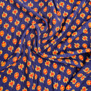 A swatch of navy blue fabric with a red crest pattern spread out on a flat surface.