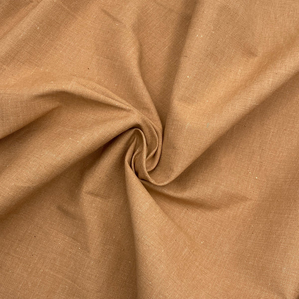 orangish brown lightweight denim fabric scrunched in a swirl to show the texture of the fabric